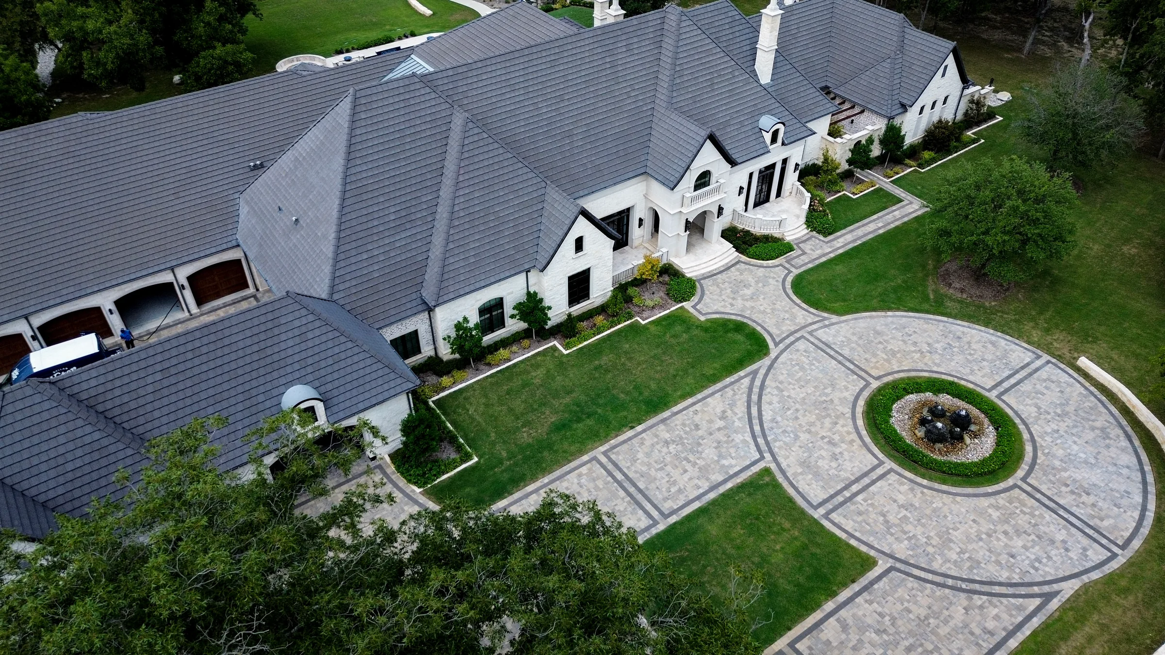 Aerial view of a circular paver motor court with dark geometric border bands