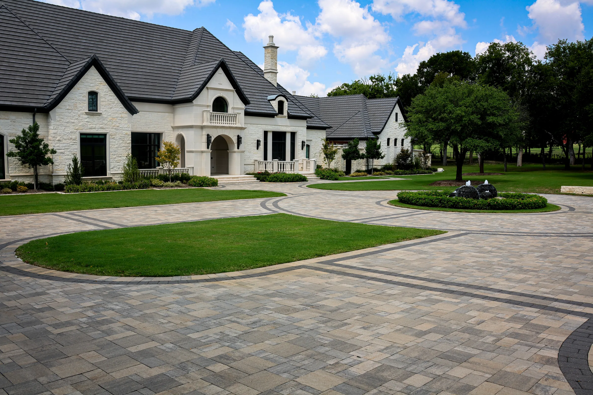 Broad estate paver motor court with contrasting curved bands