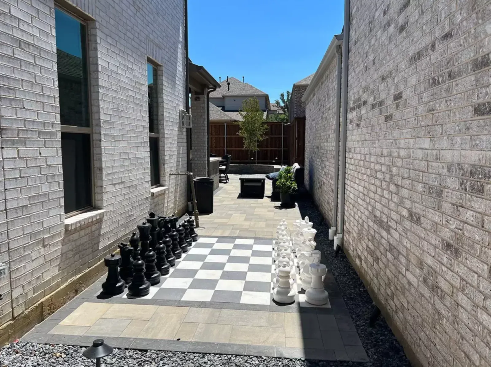 Checkerboard paver and turf court installed in a narrow side yard
