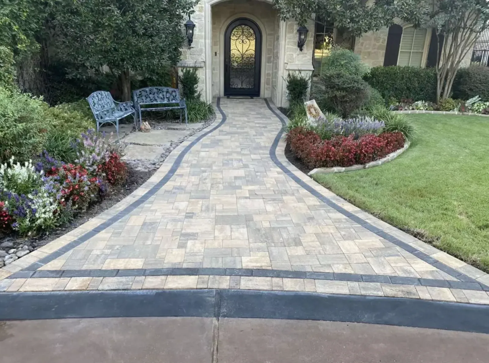 Curved multicolor paver walkway with dark borders leading to a front entry