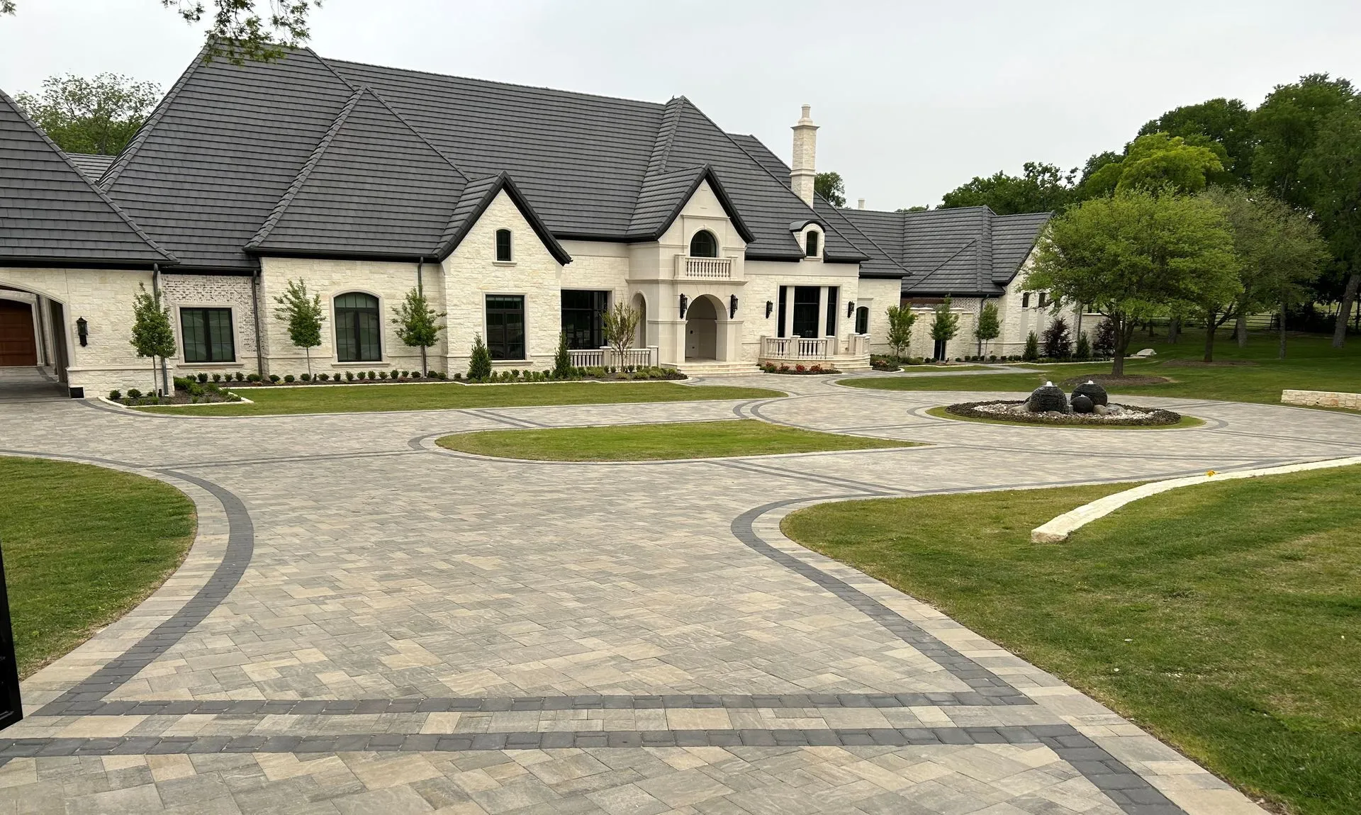 Broad estate paver driveway with contrasting bands and a circular motor court