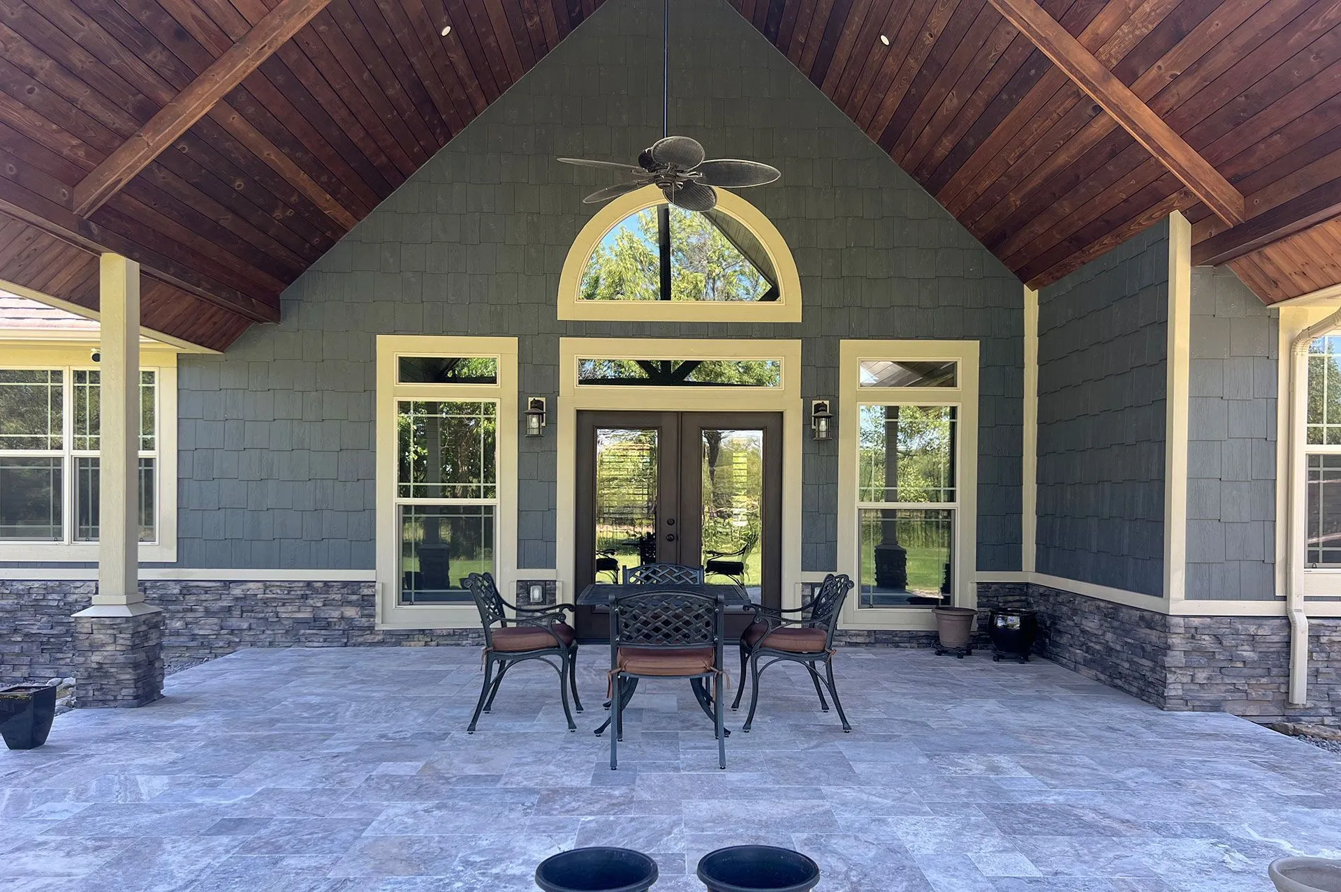 Large covered pavilion with a vaulted wood ceiling and a paver patio floor