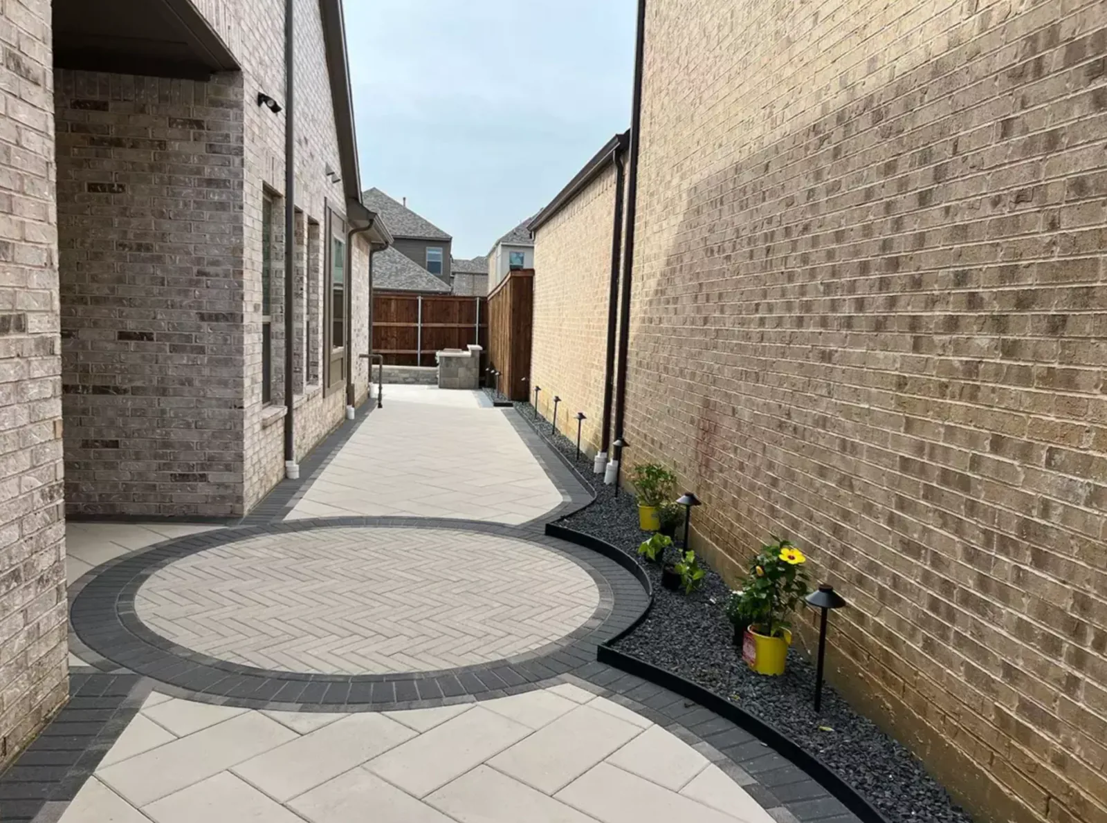 Decorative circular paver court connecting a narrow side yard
