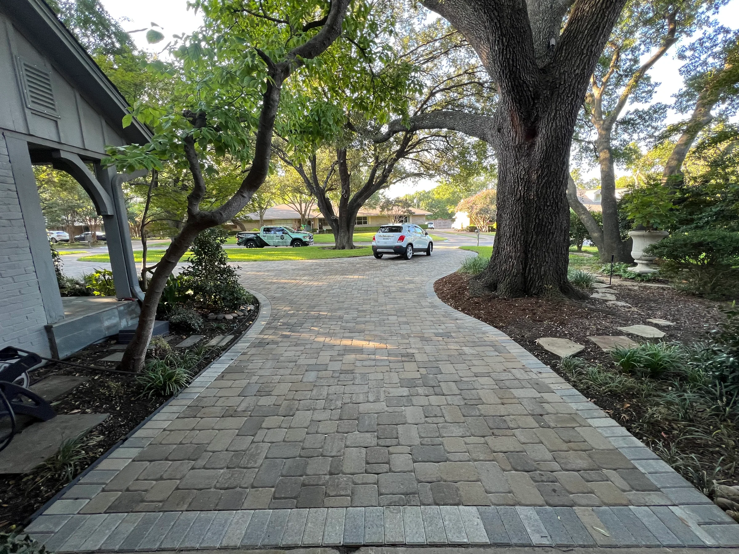 Paver walkway through a mature front yard